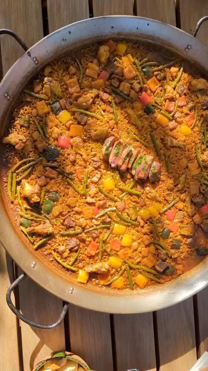 Meat Paella with Pork rib Chorizo and Seafood, presented with rosemary garnish